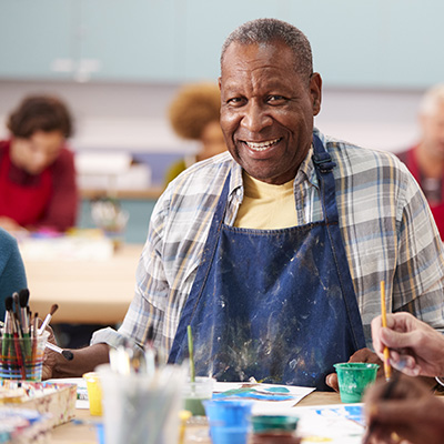 elderly man smiling in an art class